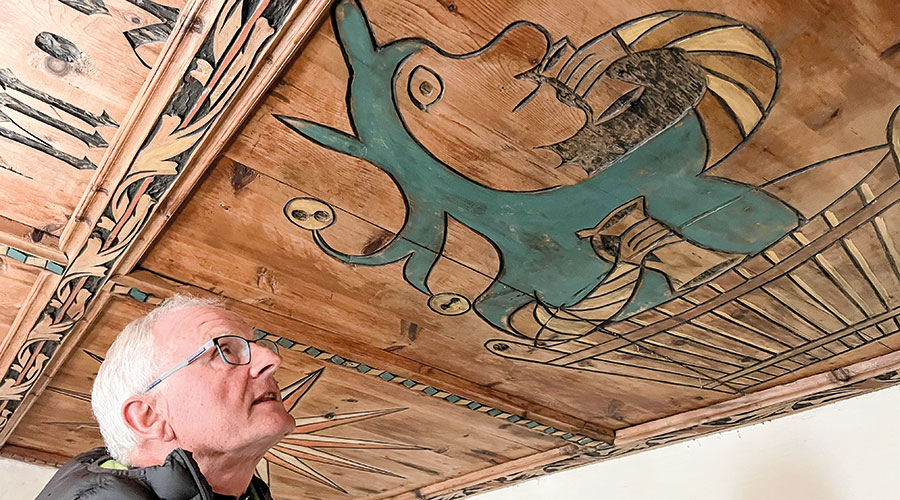 Moriggl unter der Darstellung des Narren im Waschzuber an der gotischen Flachdecke von 1523 und dem Spruch: „Item wen(n) Nar(r)en lang leben, so wer(d)en si(e) alt“.  (Foto Peter Tscholl); 