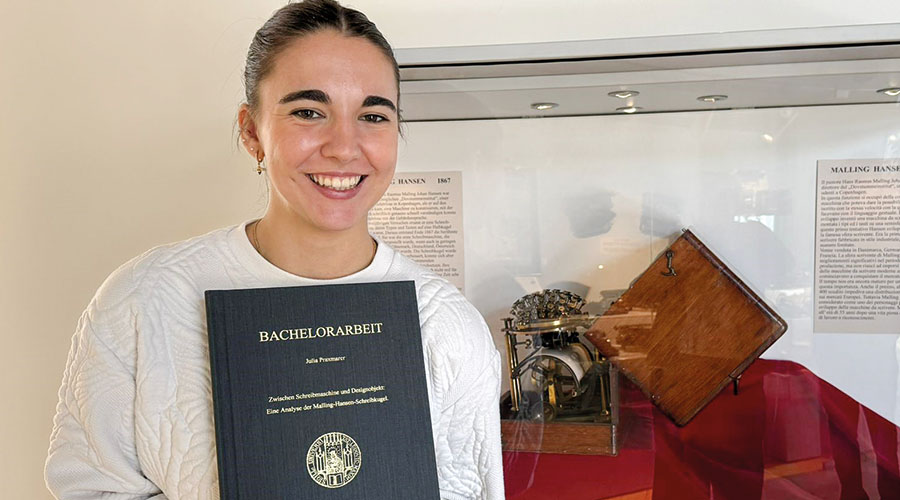 Julia Praxmarer mit ihrer Diplomarbeit vor dem Malling Hansen Modell im Museum sowie während ihres Vortrages
