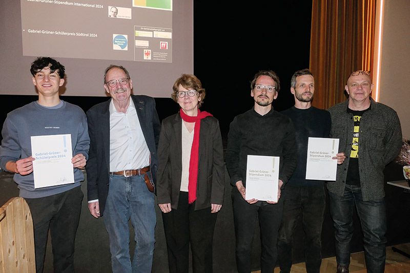 Preisverleihung im Kulturhaus von Mals. V. l.: Luis Parth, Uli Reinhardt, Ingrid Eißele, Hannes Jung, David Krenz, Peter Grüner. Grußworte sprachen Michael Pinggera vom Bildungsausschuss und Marion Januth, die Vizebürgermeisterin. Es moderierte Roman Drescher und für die musikalische Umrahmung sorgte das Trio „Schean dahin“ mit Fabian Alber, Lea Niederfriniger und Kathrin Kofler.