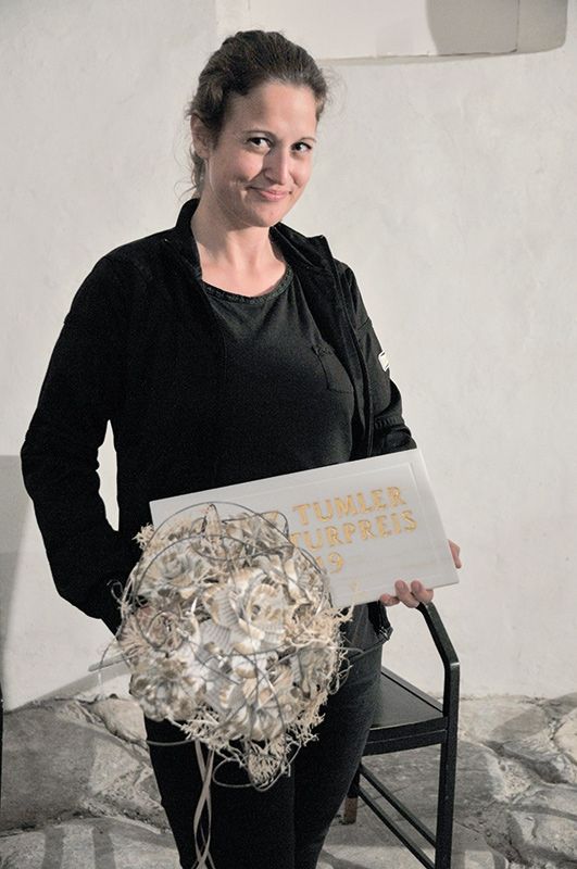 2019 freute sich  Angela Lehner über das Preisgeld, zur Verfügung gestellt von der Südtiroler Landesregierung. Auf diesem Bild strahlt sie auch über die Siegertafel (Lasa Marmo u. Josef Mayr) und den Blumengruß der Laaser Kaufleute