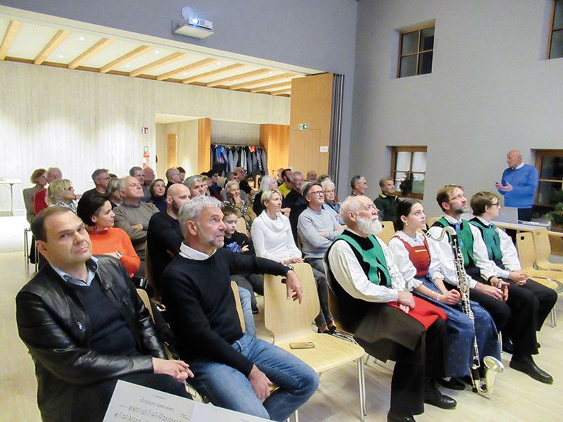 Im „Pixner Haus“, dem ehemaligen Schulhaus, wurde die Plauser Chronik vorgestellt. In der ersten Reihe v. l.: BM Jürgen Klotz, LR Arnold Schuler, Hermann Wenter, die Bläsergruppe der Musikkapelle Naturns und ganz rechts stehend: Heinrich Kainz