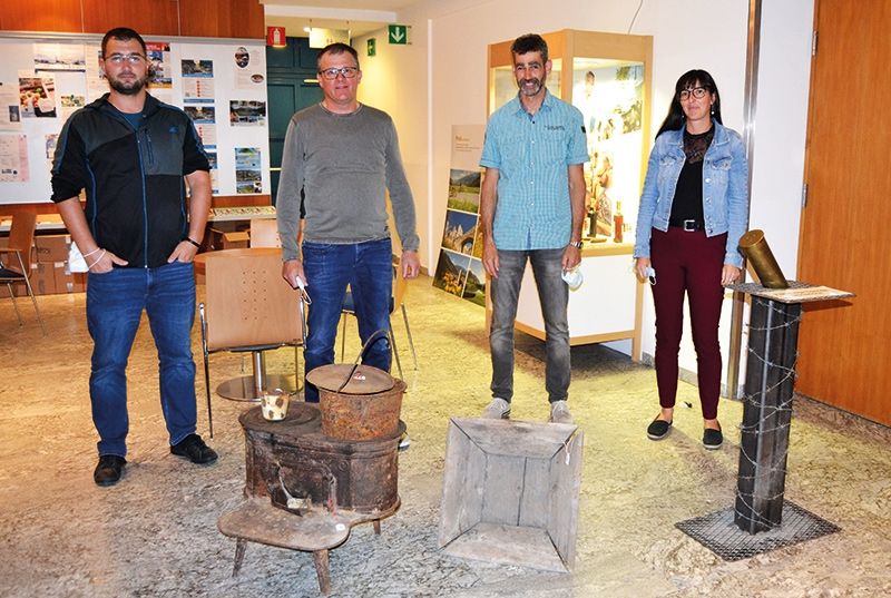 Die Filmemacher:innen bilden den Ausschuss des Ortlerfront Sammlervereins: v. l. Benjamin Tragust (Konzept, Text), Eberhard Reinstadler (Kamera, Schnitt), Gerald Holzer (Vizepräsident, Moderation), Historikerin Melanie Platzer (Text). Im Vordergrund: Ofen und Holzbehälter, originale Fundstücke von der Trafoier Eiswandstellung.