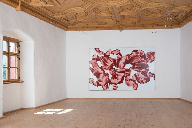 „Spielart der Skulptur, Erzeugung einer dritten Dimension. Rote Farbspuren auf silbernen Grund.“